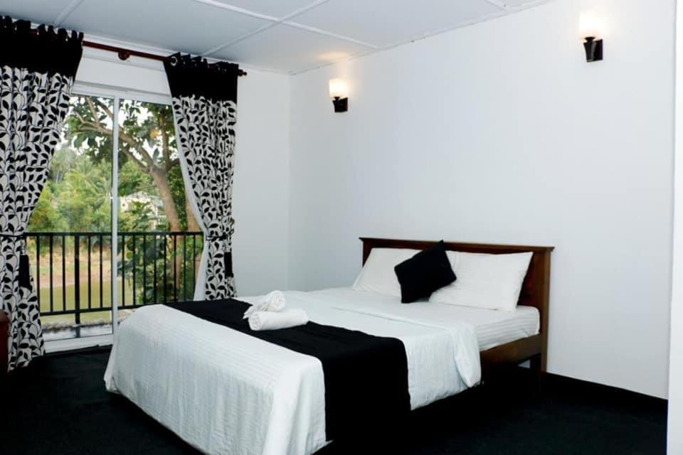 康提Sadhara River View Lodge的一间卧室设有两张床和窗户。