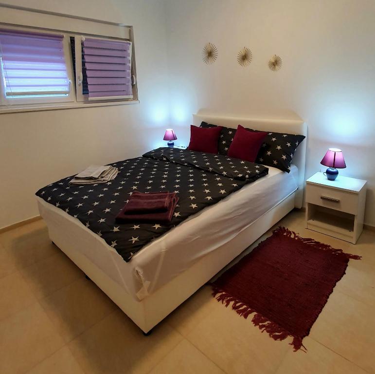 维尔蒂尼克Lux Snezana的一间卧室配有一张带红色枕头的大床