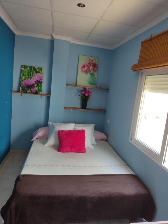 马萨龙港Playa Rihuete 2的一间拥有蓝色墙壁的卧室和一张带红色枕头的床