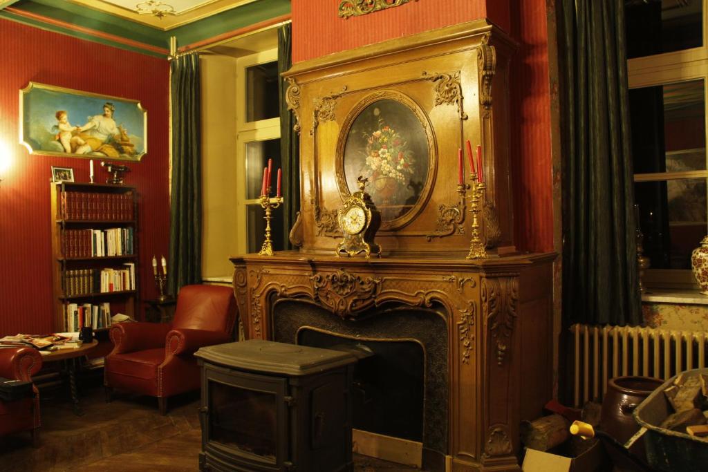 Faubourg Saint-Germain特罗姆科特旅馆的客厅设有壁炉,配有时钟