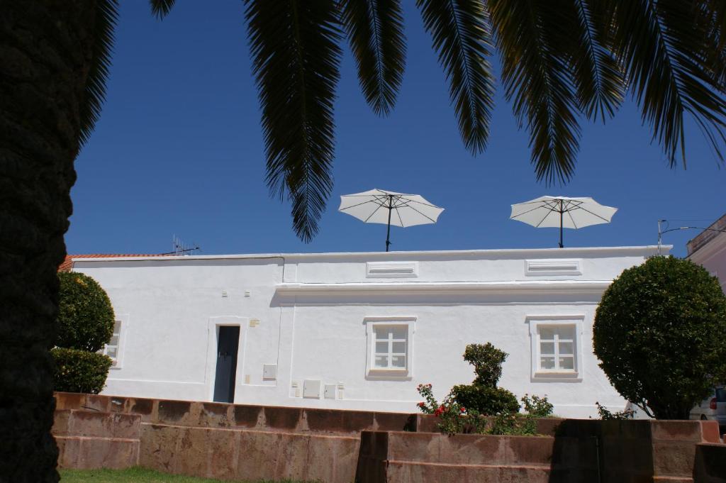 西尔韦斯Casa do Largo Silves的屋顶上带两把遮阳伞的白色房子
