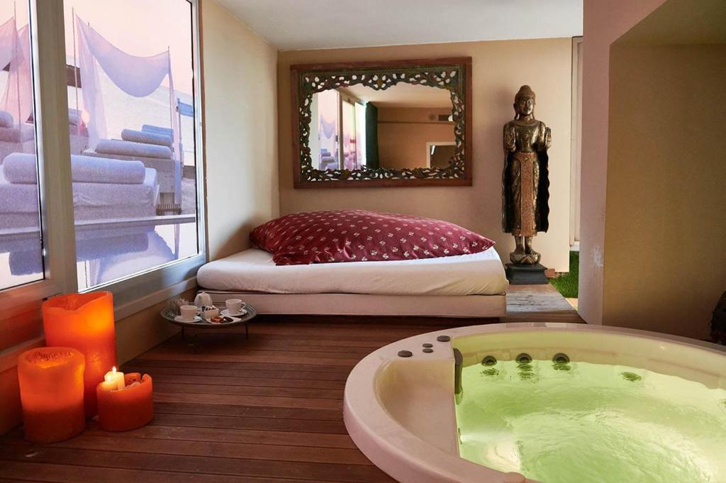 丽都迪萨维奥维士塔梅赫套房酒店的带浴缸的浴室以及带镜子的床