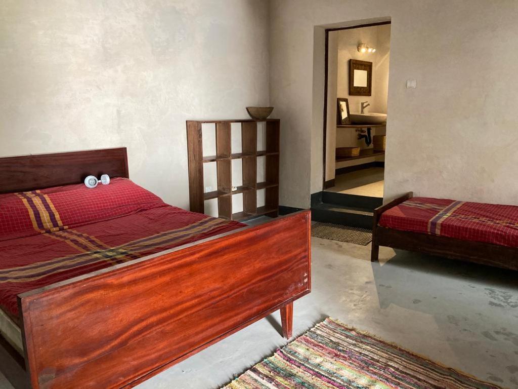 莫桑比克岛Casa Fabula的一间卧室配有一张带红色棉被的木床
