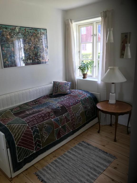 斯泰厄Vidunderligt hus på smukke Nyord的一间卧室配有一张床、一张桌子和一个窗户。