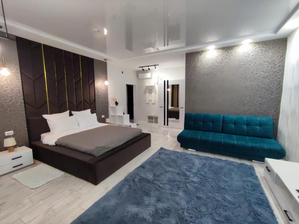 乌拉尔斯克Zest hotel & spa的一间卧室配有一张床和一张蓝色的沙发