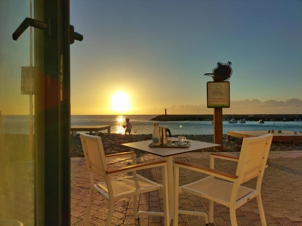 圣尼科拉斯村De Sebastian 1 - estudio frente al mar的海滩上的桌椅和日落