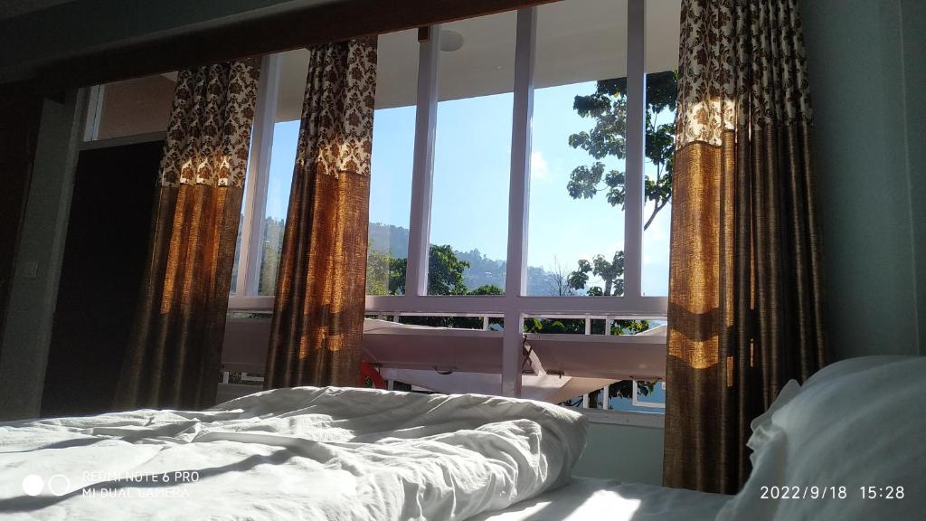 佩林Mandavya homestay的一间卧室设有一张床和一个大窗户