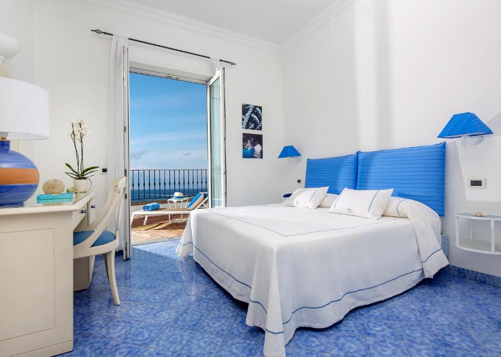 卡普里Relais Maresca Luxury Small Hotel & Terrace Restaurant的一间卧室配有一张床、一张书桌和一个窗户。