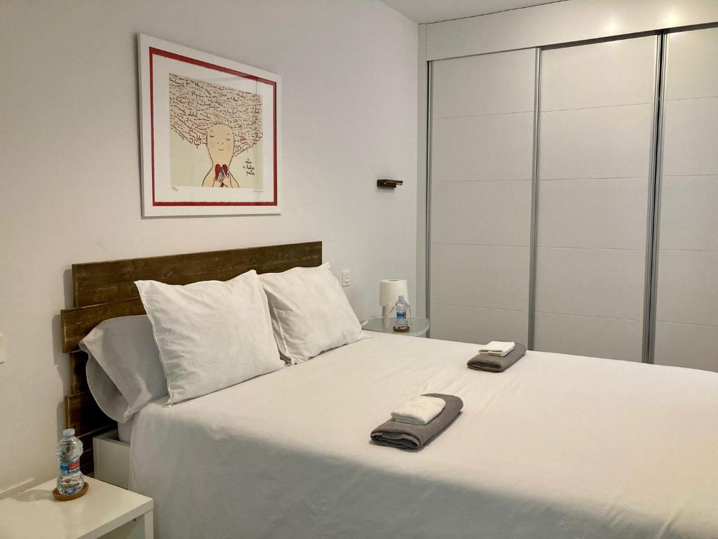 萨拉戈萨Apartamento centro con parking privado的卧室配有一张白色大床和两条毛巾