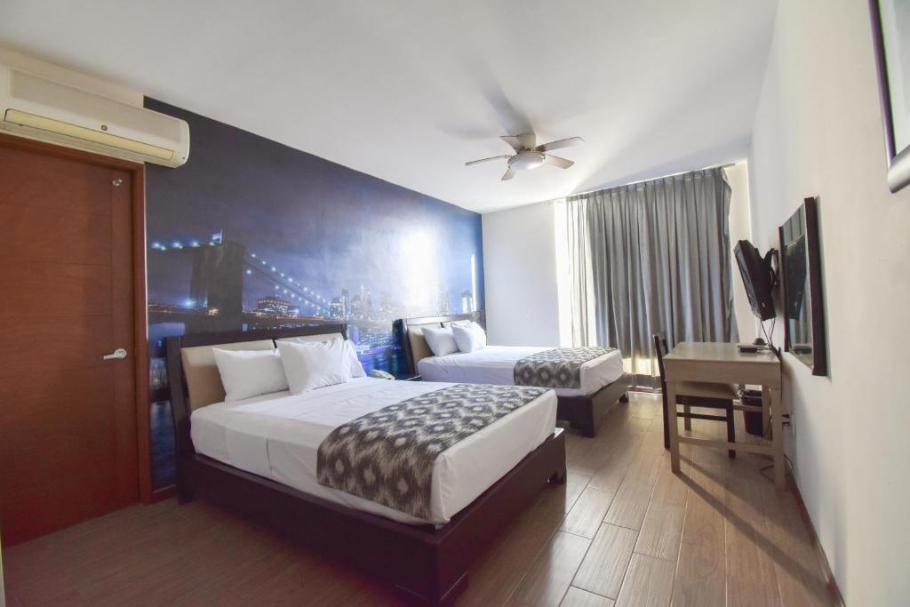 瓜达拉哈拉Hotel TÖTEM Guadalajara的酒店客房带两张床、一张书桌和一间卧室