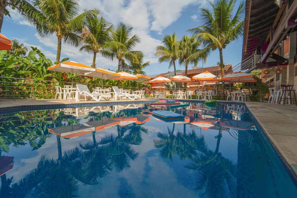 坎布里卡姆布里普拉亚酒店的一个带椅子和遮阳伞的游泳池以及棕榈树