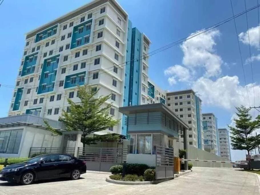 伊洛伊洛Spacious 2 bedroom 42sqm condo unit的停在大楼前的汽车