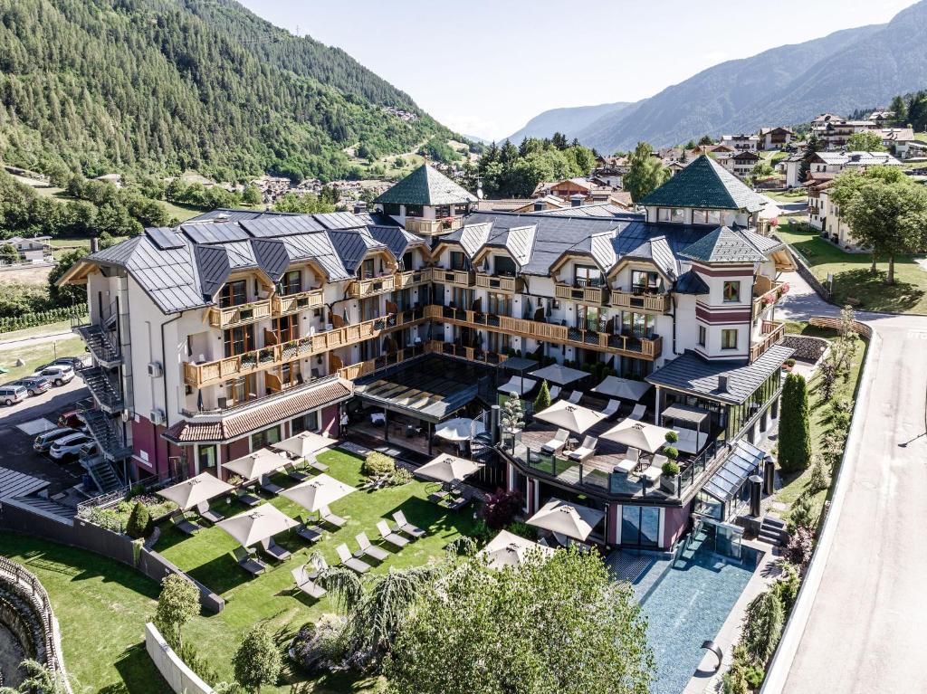 科姆梅扎杜拉Tevini Dolomites Charming Hotel的享有酒店空中景色,以山脉为背景