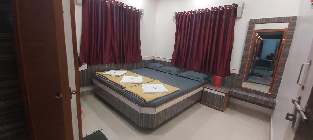舍地Sai Raghunandan Guest House的一间小卧室,配有一张床和镜子
