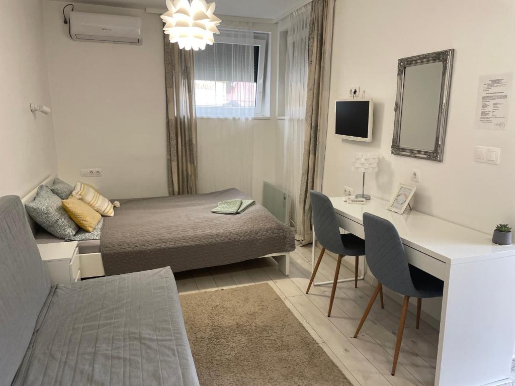 豪伊杜索博斯洛Sunrise Apartment的一间小卧室,配有一张床和一张桌子及椅子