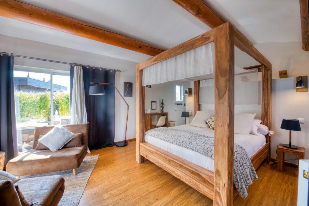 埃加利埃Mas des Cigales的一间卧室配有天蓬床和沙发