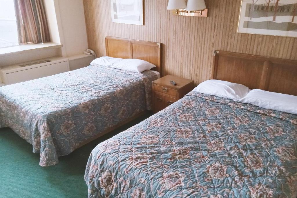 WinfieldBlue Way Inn & Suites Winfield的酒店客房设有两张床和窗户。