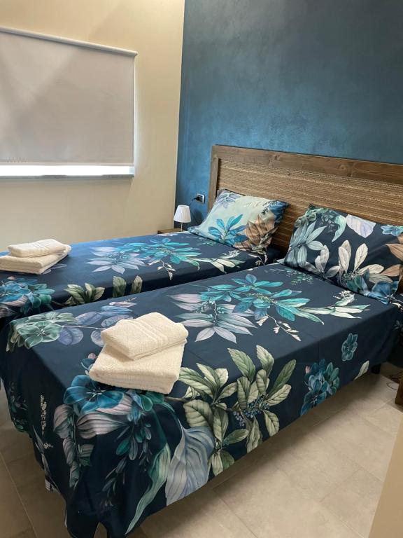 菲纳莱利古雷B&B La DORMERIA的一间卧室配有两张蓝色和绿色的床