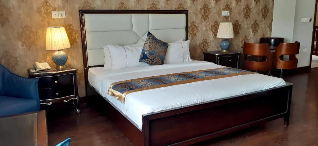 卡拉奇Swisstel Cottage的一间卧室配有一张带2个床头柜的大床