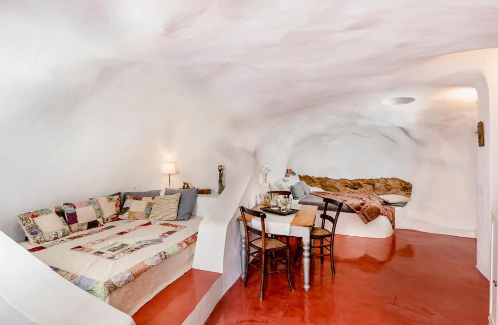 安坡里奥圣托里尼Traditional Farmers Caves的配有一张床和一张桌子及椅子的房间