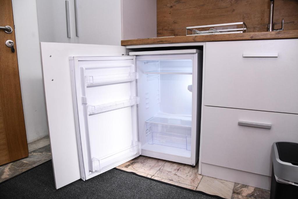 新帕扎尔Demir Apartmani的厨房里空着冰箱,门开