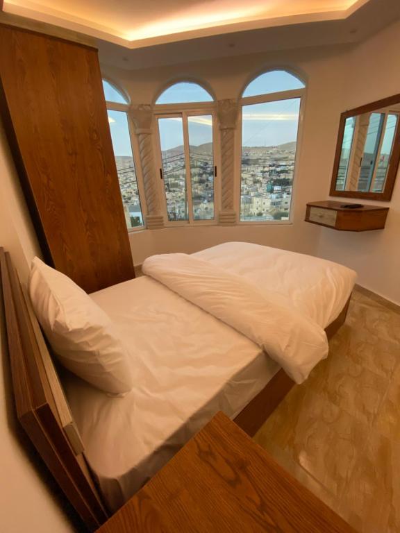 瓦迪穆萨Petra Family Hotel的配有窗户的客房内的一张大床