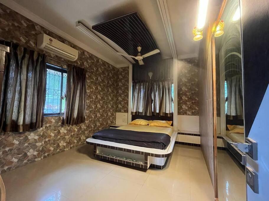 罗纳瓦拉Homely condo in Lonavala的一间卧室配有一张床和一台电视。