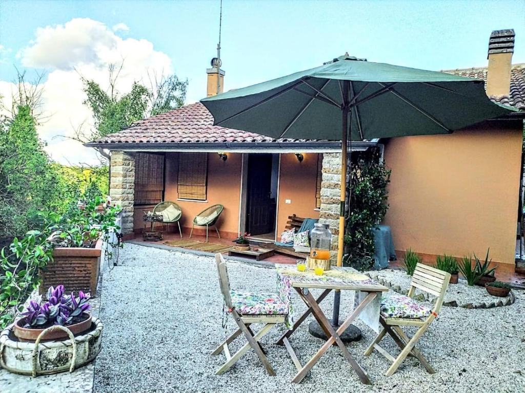 龙奇廖内roncio' cottage的庭院配有桌椅和遮阳伞。