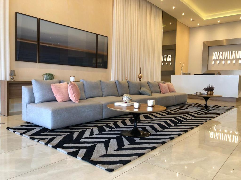 里贝朗普雷托Apartamento Wi-fi, Split, Estacionamento e Piscina的客厅配有蓝色的沙发和桌子