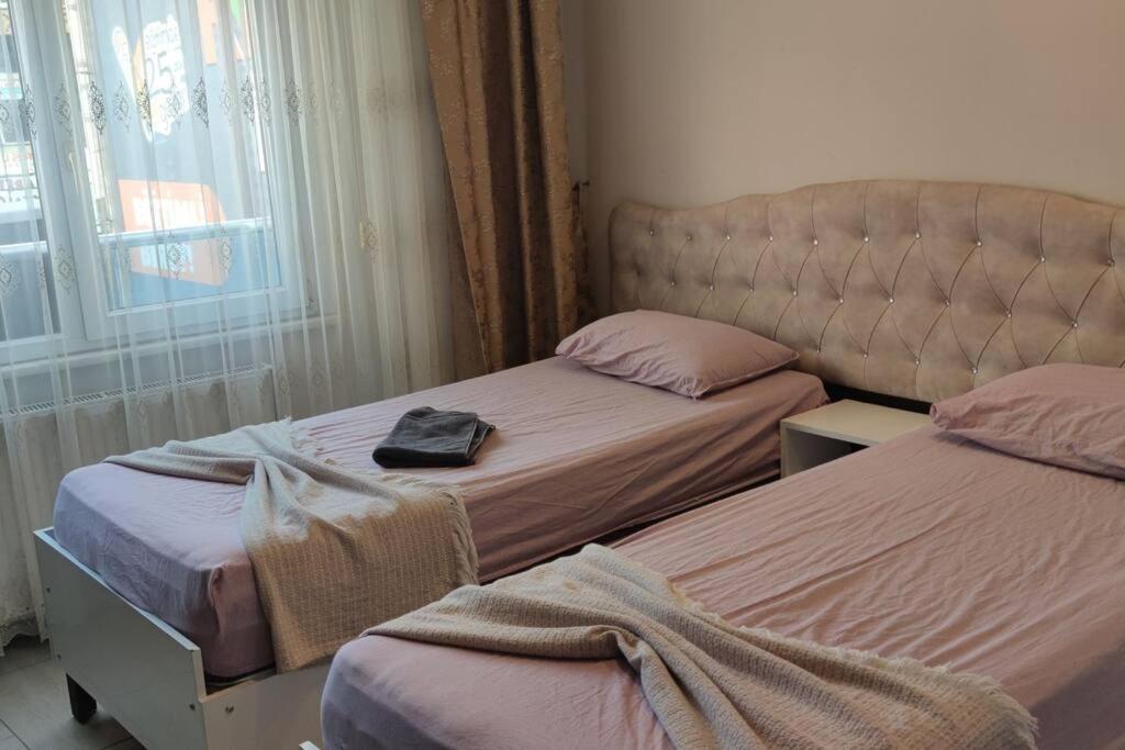 伊斯坦布尔Midtown Hotel Apartments 401 (2+1)的一间卧室配有两张床,床上备有一个袋子