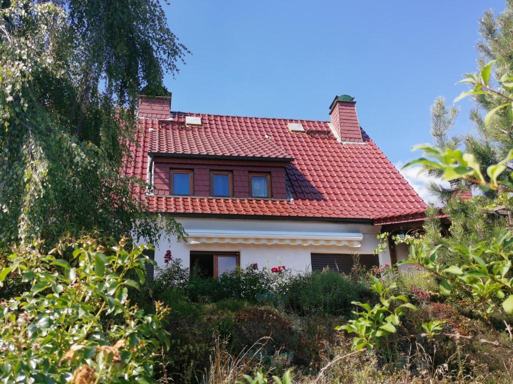 (H)Auszeit的一座有红色屋顶和灌木的房子