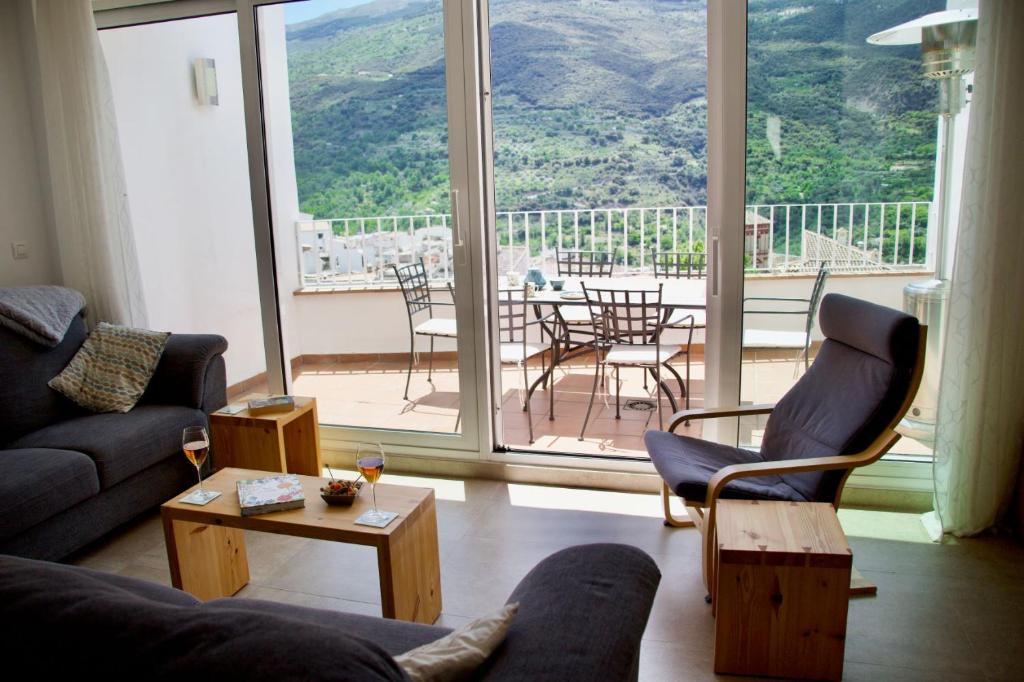 圭哈尔谢拉Guejar Sierra House with Spectacular Views的带沙发和椅子的客厅以及大窗户。