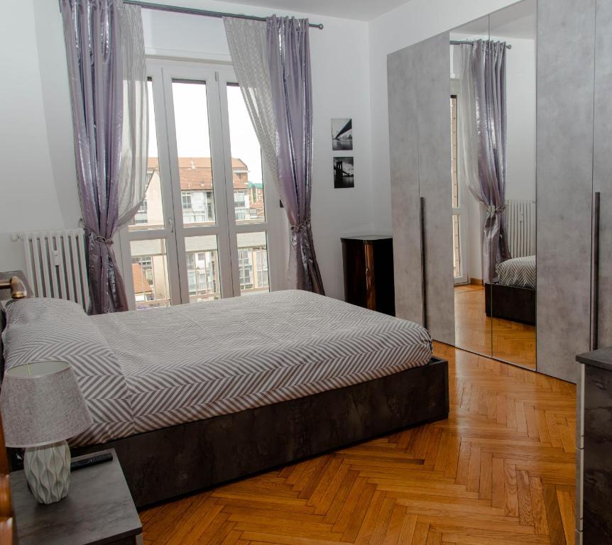 都灵A casa di Ivy e Baby的一张大床,位于带大窗户的房间里