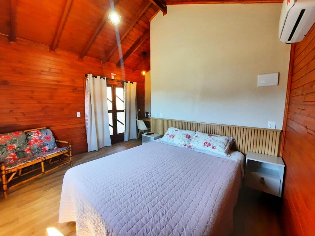 乌鲁比西Pousada Morada dos Sonhos的木制客房内的一间白色床卧室
