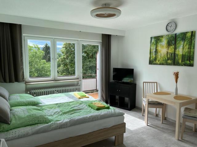 斯图加特Ruhiges und klimatisiertes Apartment的一间卧室配有一张床、一张桌子和一个窗户。