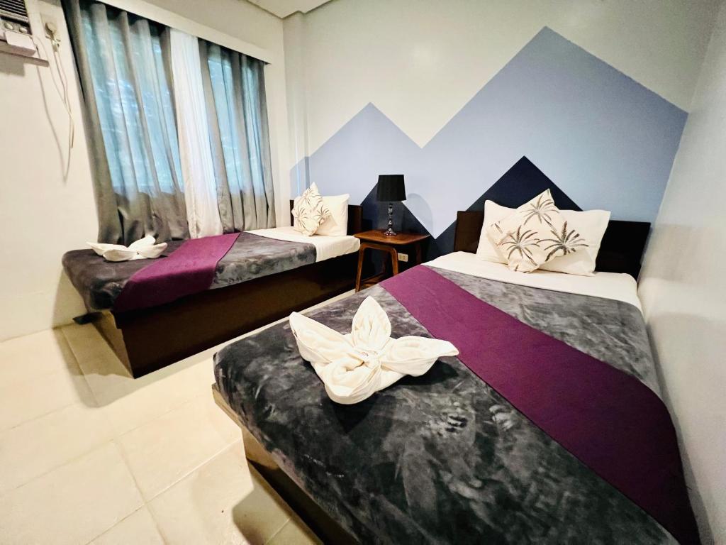科隆Coron Ecolodge的酒店客房,配有两张带鲜花的床