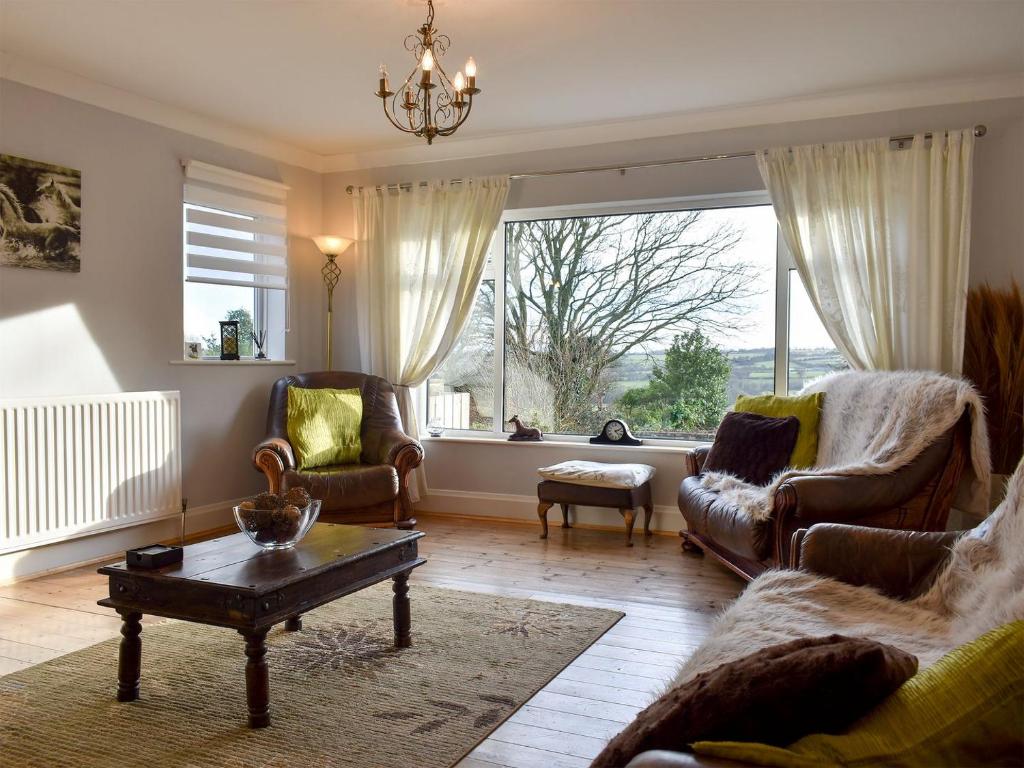 HamsterleyCotswolds Cottage的带沙发和椅子的客厅以及大窗户。