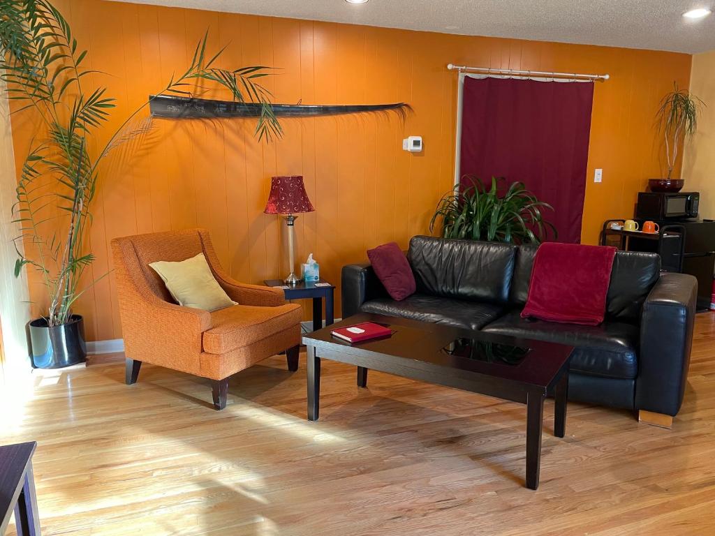 安克雷奇Turnagain Guest House的客厅配有真皮沙发和椅子