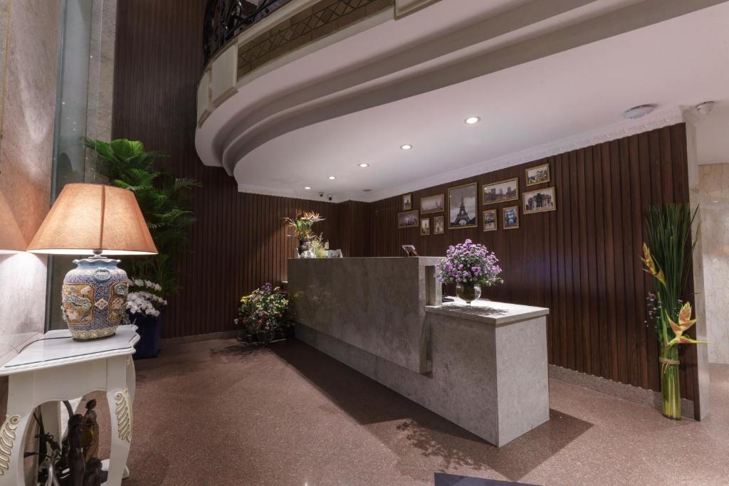 胡志明市罗斯兰科普酒店的大堂设有前台,墙上挂着鲜花