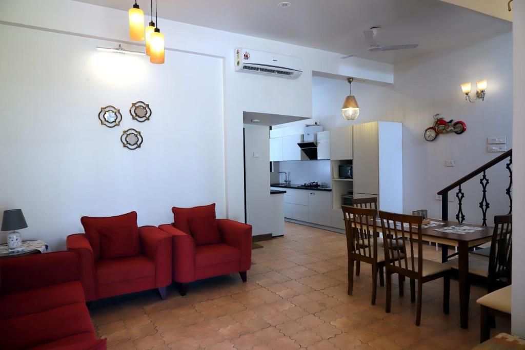 瓦尔恰Agosto @Aansav Verde Fatrade Varca GOA 3 BR Villa的客厅以及带红色椅子和桌子的厨房
