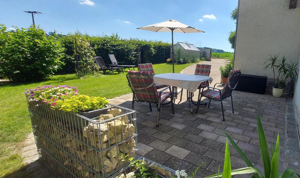 RotthalmünsterRuhig gelegene Ferienwohnung mit großer Terrasse的庭院配有桌椅和遮阳伞。