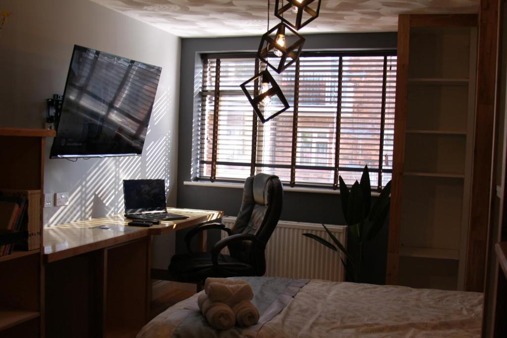 朴次茅斯College Street Abode的一间卧室配有桌子、椅子和窗户