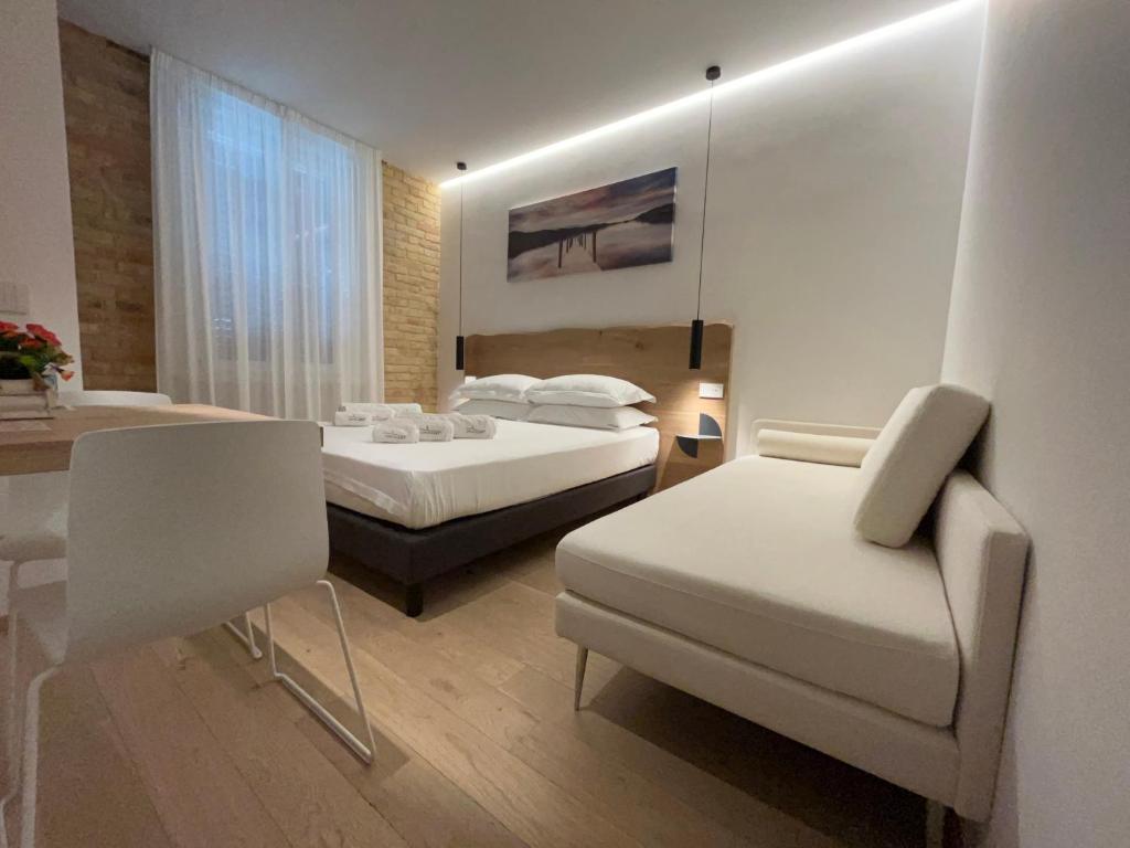 西维尔诺瓦·马尔凯Civitaloft Luxury Rooms的一间卧室配有两张床、一把椅子和一张桌子