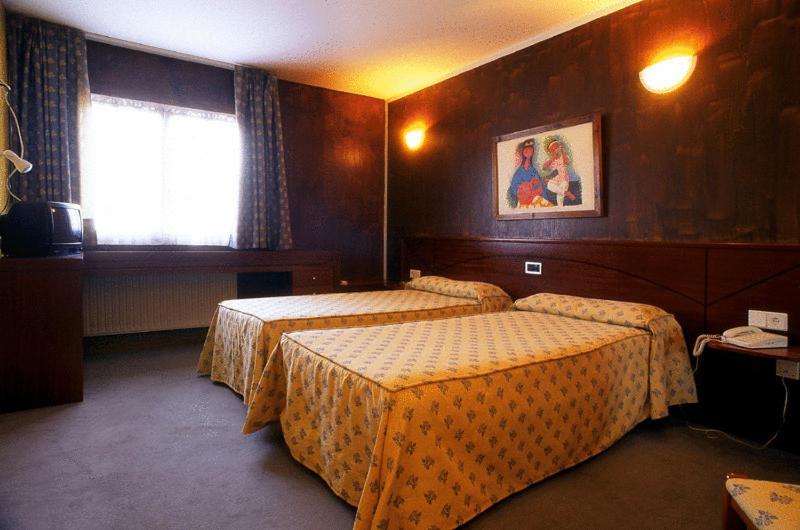 Nava纳瓦别墅酒店的酒店客房设有两张床和窗户。