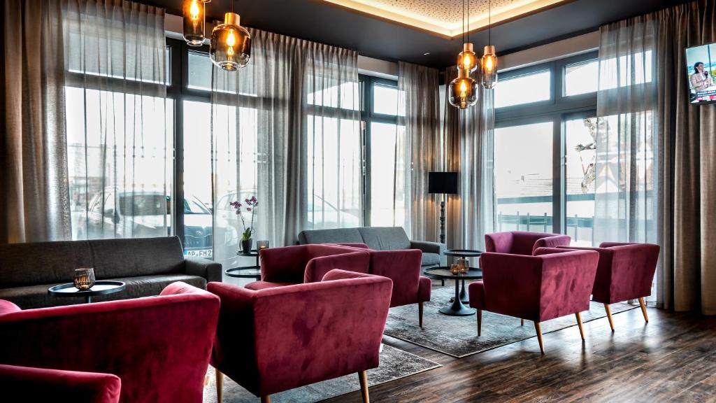 布尔高Burgau Hotel Sonnenhof的客厅设有桌椅和窗户。