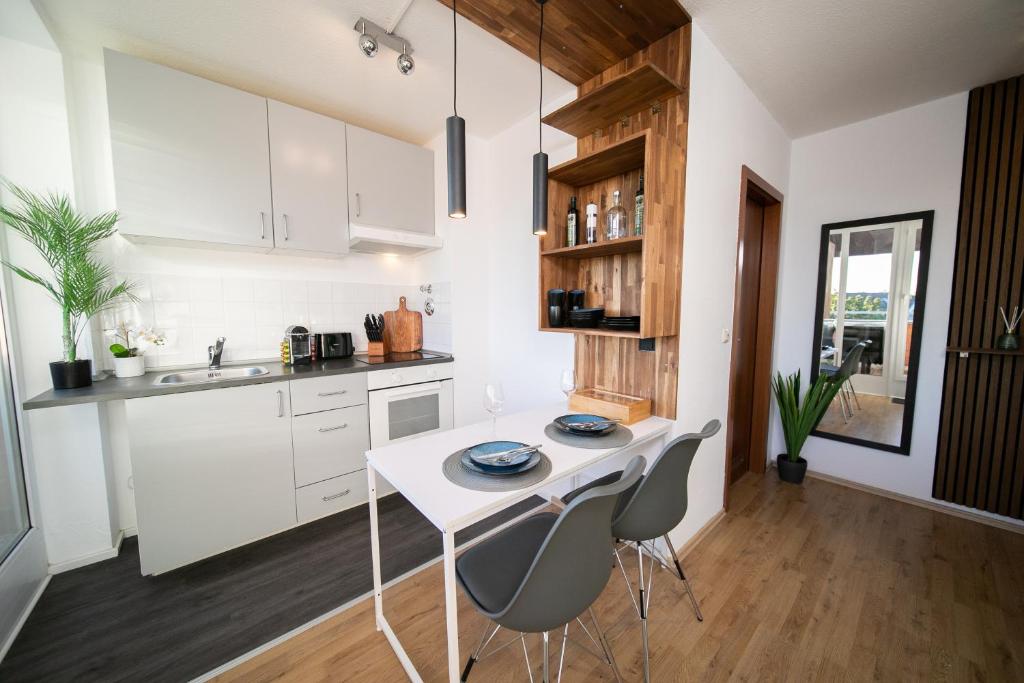 诺伊斯Studio WHITE - Central - Balcony - Fair - Kitchen的厨房配有白色橱柜和白色的桌椅