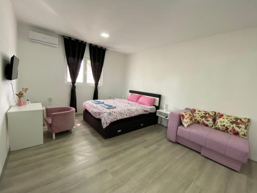 扎耶查尔Apartmani Home的一间卧室配有一张床和一张沙发