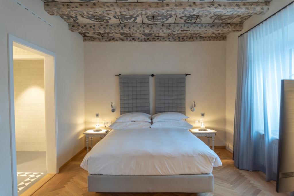 穆里CASPAR Swiss Quality Hotel的一间卧室配有一张大床和两张桌子