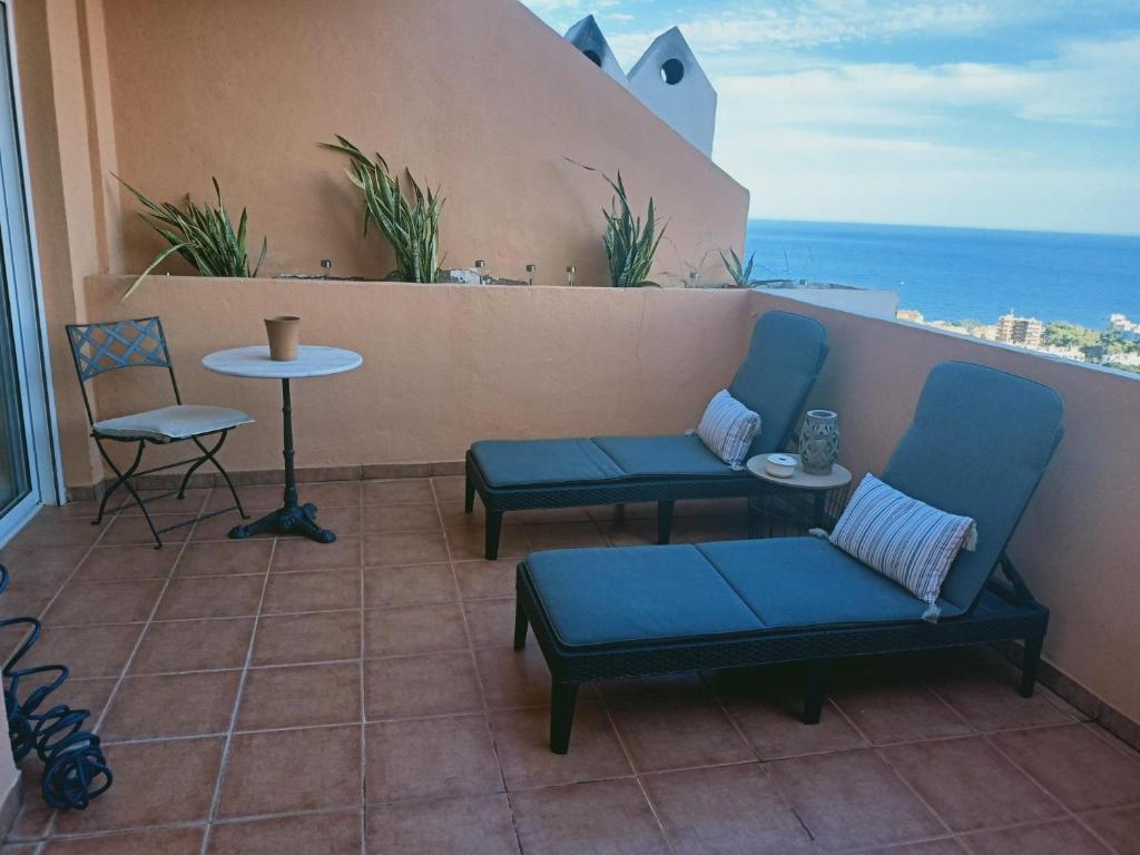 阿瓜杜尔塞Habitación con vistas的阳台配有2把蓝色椅子和桌子