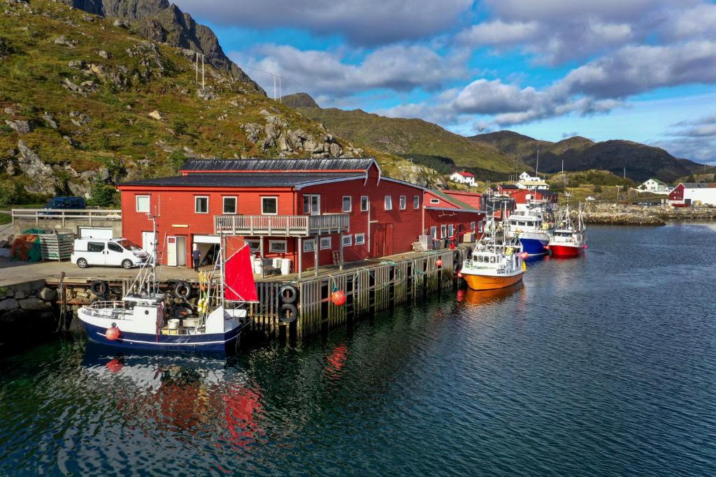 巴尔斯塔Fish factory -The real Lofoten experience的一群船停靠在港口,有一座红色的建筑